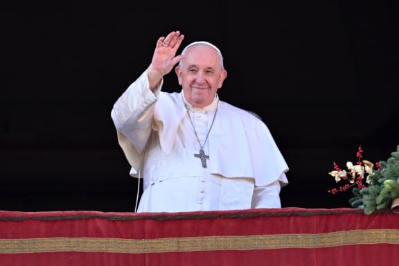 (FILES) Pope Francis waves to the crowd as he appears at the balcony to deliver his Christmas Urbi et Orbi blessing in St. Peter's Square at The Vatican on December 25, 2022.  The Vatican on December 12, 2023 approved blessings for same-sex couples but insisted they must not be established as a Catholic rite nor given in contexts related to civil unions or weddings. In a document approved by Pope Francis, the Vatican backed "the possibility of blessings for couples in irregular situations and for couples of the same sex" but "this blessing should never be imparted in concurrence with the ceremonies of a civil union, and not even in connection with them". (Photo by Andreas SOLARO / AFP)