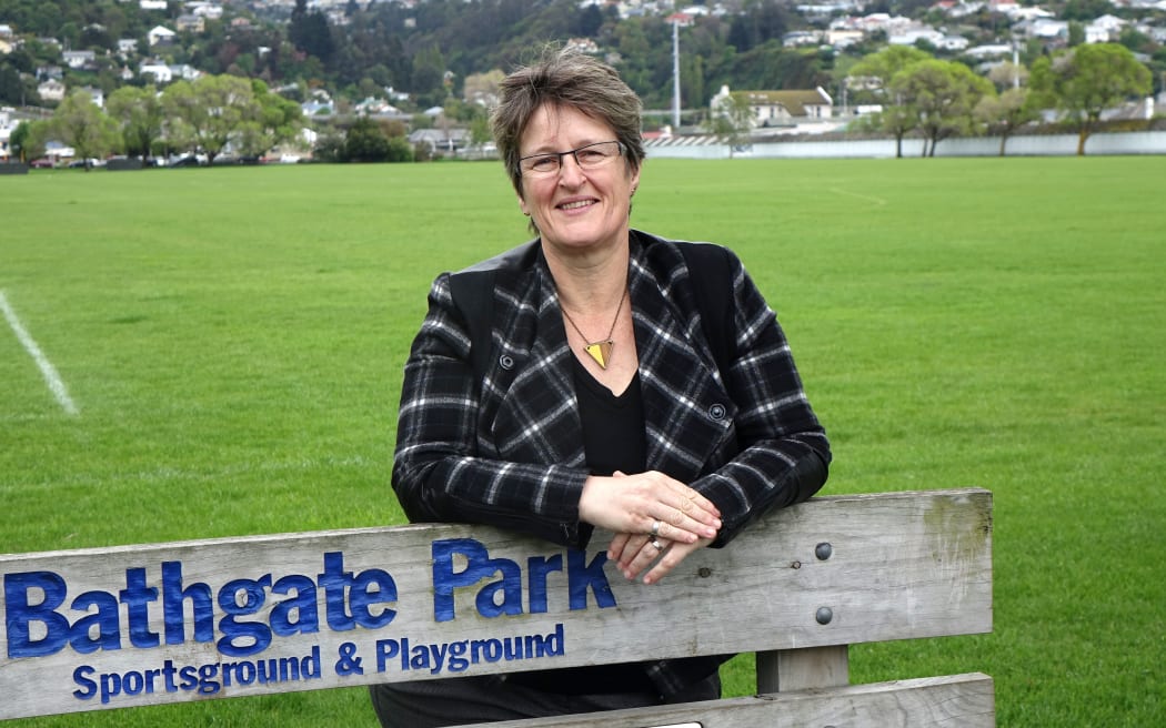 Sue Bidrose stands in front of a playing field in South Dunedin