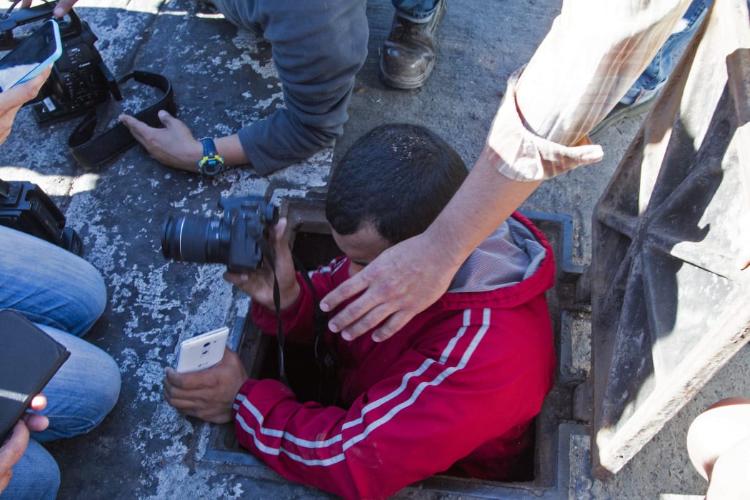 A journalist enters a manhole of the sewer system through which drug kingpin Joaquin "El Chapo" Guzman tried to escape.