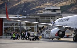 Passengers board commercial jet at Queenstown Airport.
