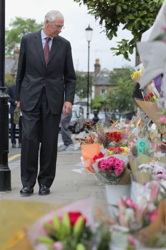 Sir Martin Moore-Bick looks at flowers left in tribute to the victims as he leaves St Clement's Church near the Grenfell Tower block in west London on June 29, 2017.