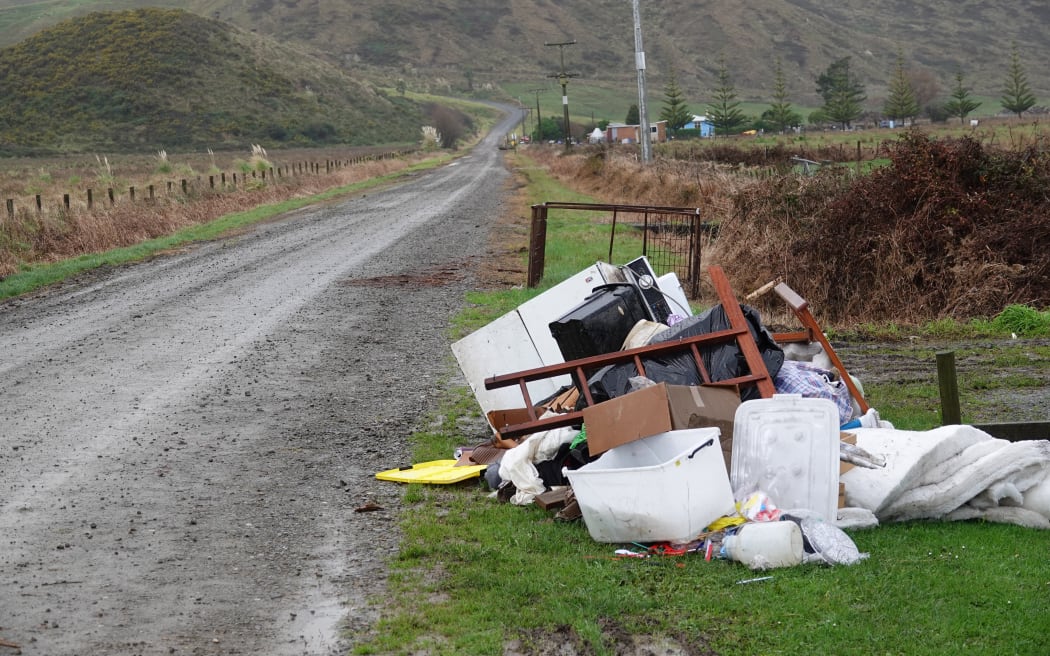 Flood-damaged household items sit beside Ngamotu Road almost three weeks after it was flooded.