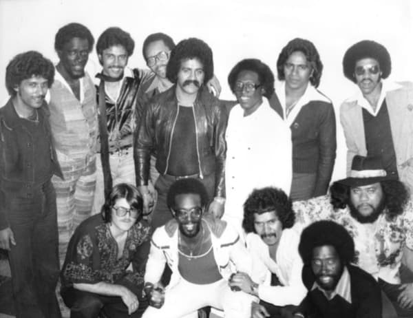 A big group of '70s looking men in a black and white photograph.