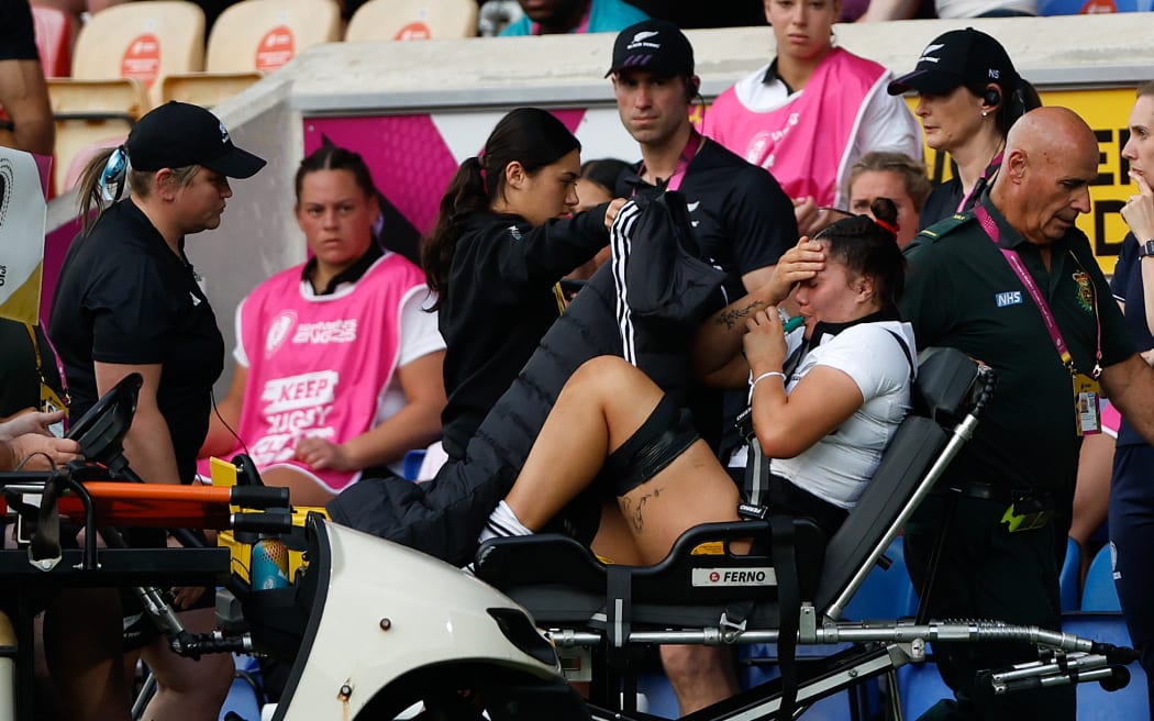 Kalpo Olsen-Baker of New Zealand leaves the pitch with a badly injured leg.