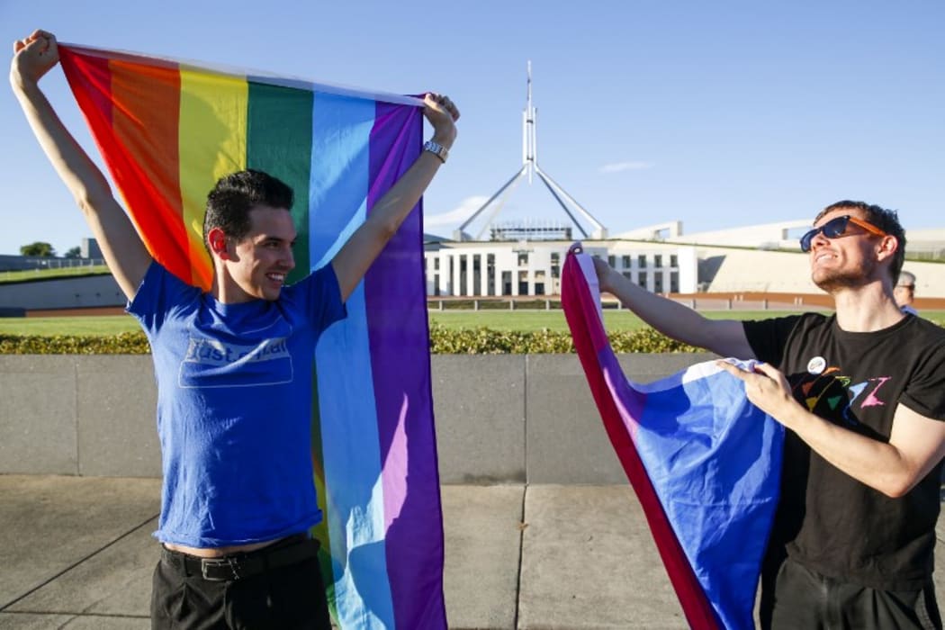 Equality ambassadors and volunteers from the Equality Campaign celebrate as they gather in front of Parliament House in Canberra.