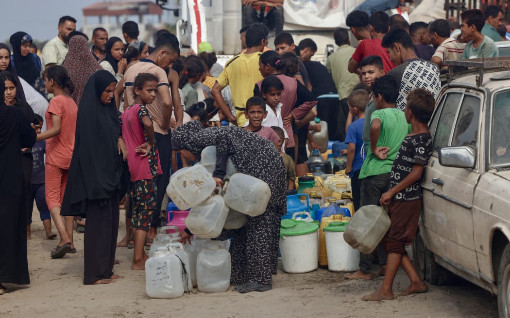 Palestinians queue to fill up on drinking water in the sweltering heat in the Mawasi area of Khan Yunis in the southern Gaza Strip on 12 August, 2025.
