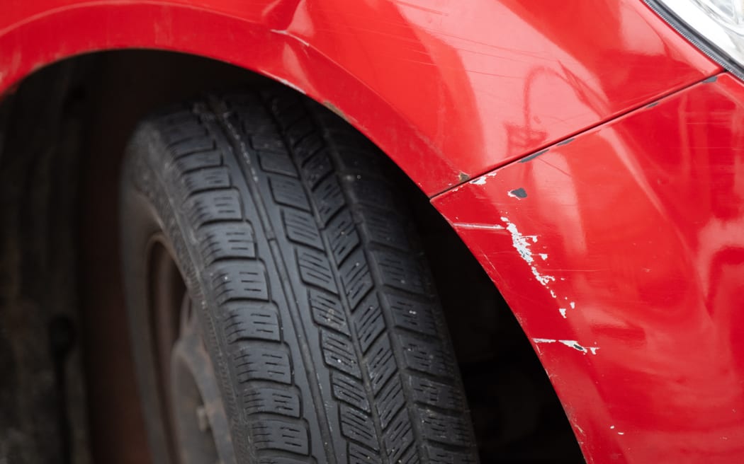 A red car is parked in a parking space with a fender bender. Photo: Robert Michael/dpa (Photo by ROBERT MICHAEL / DPA / dpa Picture-Alliance via AFP)