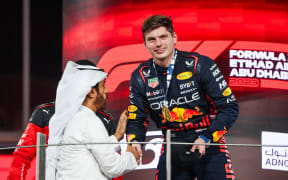 Max Verstappen receives the Abu Dhabi Grand Prix trophy from FIA president Mohammed Ben Sulayem, 2023.