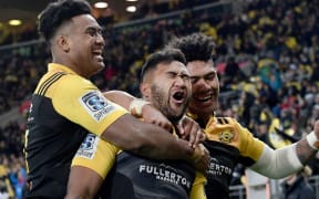 Hurricanes' Vince Aso celebrates his try with team mates Julian Savea (R and Ardie Savea (L) during the Hurricanes vs Cheetahs Super Rugby match in Wellington.