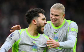 Rayan Cherki (L) of Manchester City celebrates with team-mate Erling Haaland after scoring a goal.