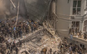 Emergency and rescue personnel along with medics and others clear the rubble of the destroyed building of Ohmatdyt Children's Hospital following a Russian missile attack in the Ukrainian capital of Kyiv on July 8, 2024, amid Russian invasion in Ukraine. Russia launched more than 40 missiles at several cities across Ukraine on July 8, 2024 in an attack that killed at least 20 people and smashed into a children's hospital in Kyiv, officials said.