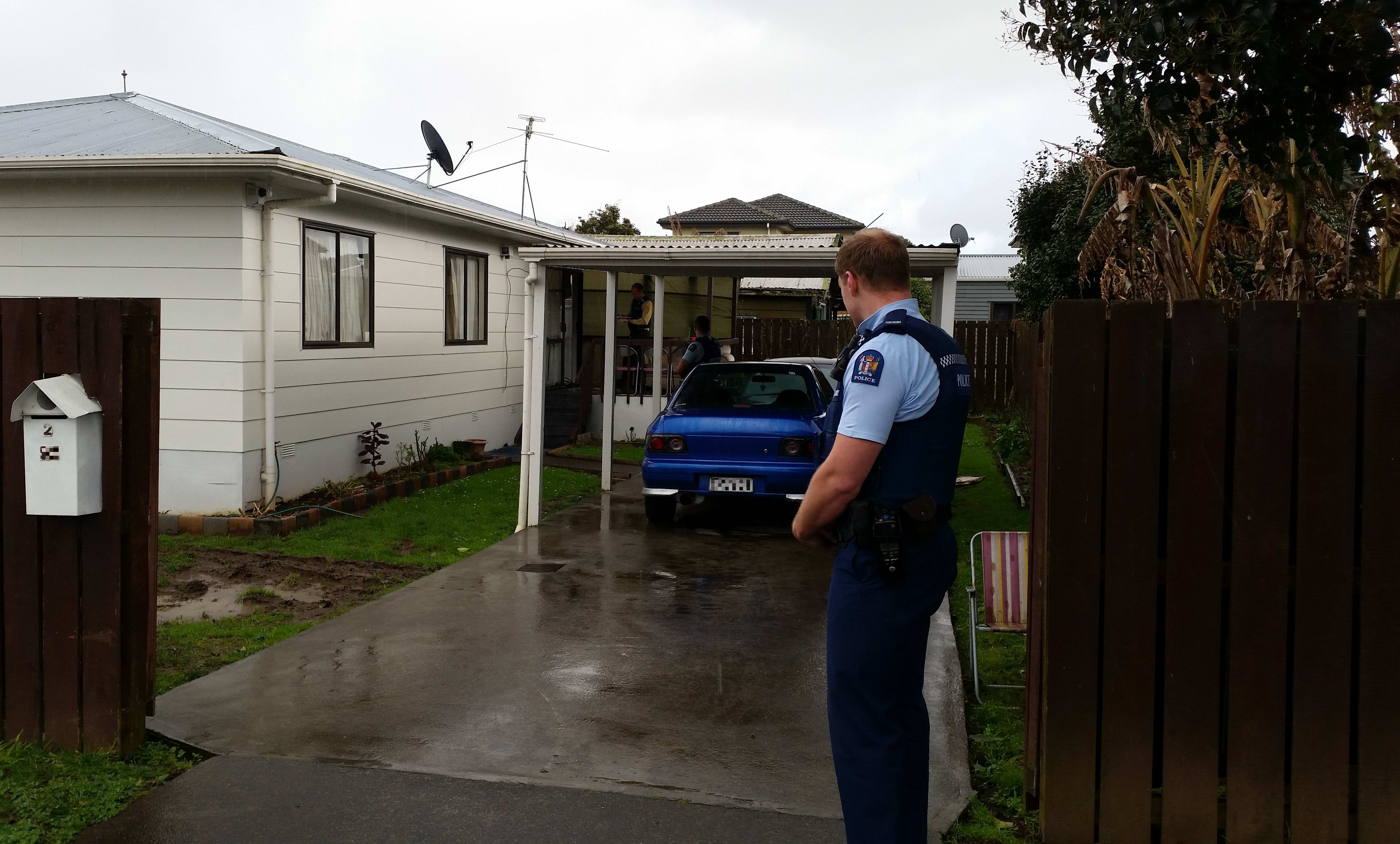Armed police guard the family home in Mangere while the search continues.
