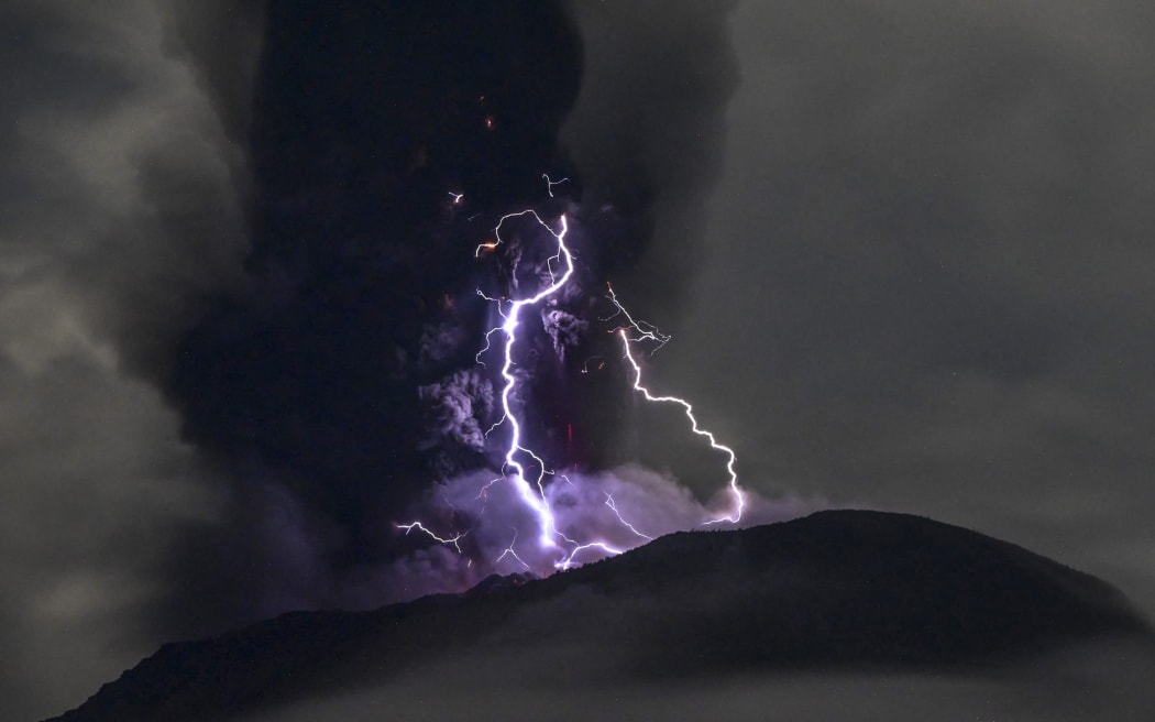 Mount Ibu spewing volcanic ash as lightning strikes, as seen from the monitoring post in Indonesia's West Halmahera, North Maluku, on 18 May, 2024.