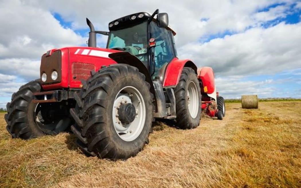 Tractor, hay bales on farm (stock photo)