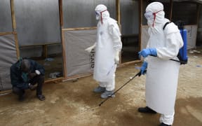 A man thought to be suffering from the Ebola virus waits to receive treatment from medical staff at Island hospital in the Liberian capital Monrovia.