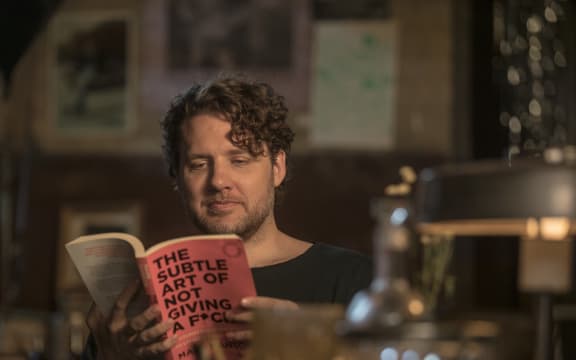 Self Help author Mark Manson with his book The Subtle Art of Not Giving A F**K