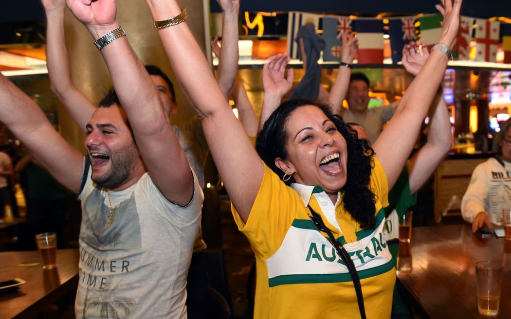 Australian fans celebrate in a Sydney bar after watching the Wallabies defeat Scotland in their Rugby World Cup quarter-final match played in England on October 19, 2015. AFP PHOTO/William WEST