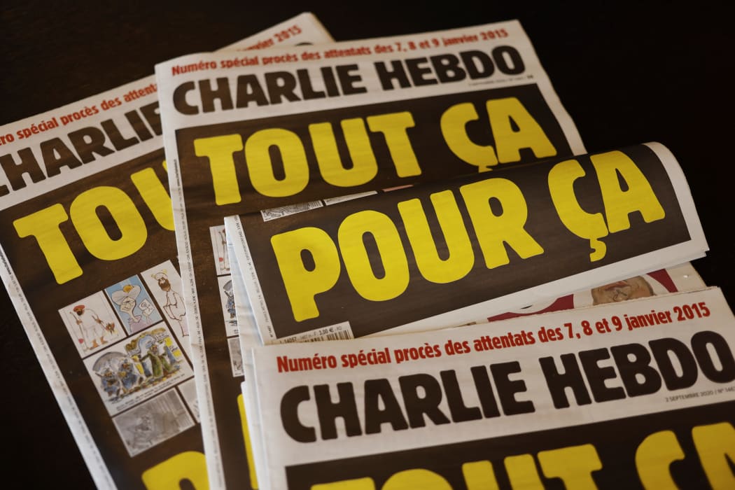 This picture taken on September 1, 2020 in Paris shows covers of French satirical weekly Charlie Hebdo reading "All of this, just for that," to be published on September 2 to mark this week's start of the trial for 14 accused in January 2015 jihadist attacks in Paris.