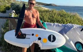 Australian surfer Andy McDonald with the remains of his gear after a close encounter with a shark.