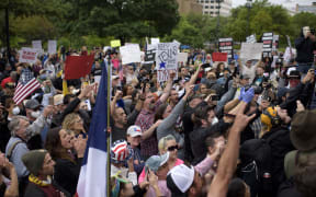 Protesters yell in unison when Infowars owner Alex Jones arrives to the "Reopen America" rally on April 18, 2020 at the State Capitol in Austin, Texas.