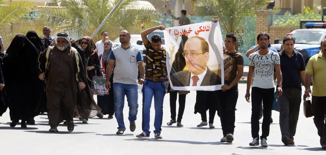 Iraqis carry a portrait of outgoing prime minister Nouri al-Maliki during a rally in his support.
