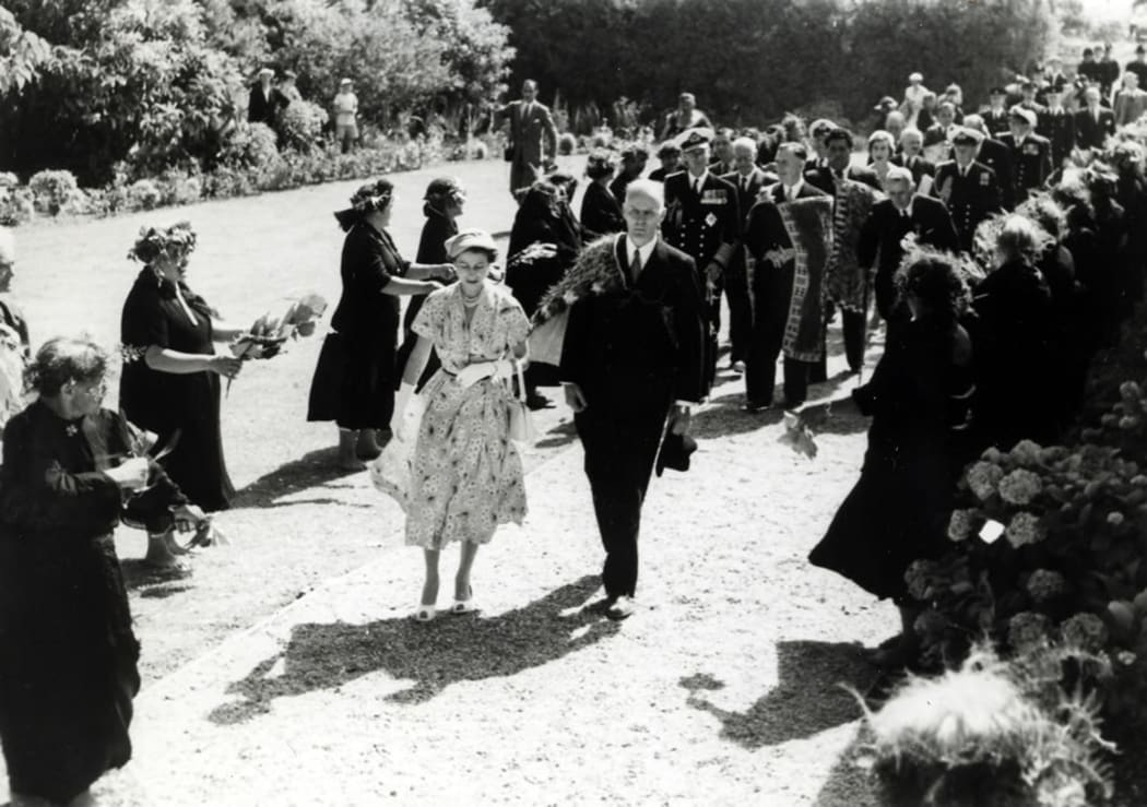 The Queen, escorted by E.B. Corbett, the Minister for Maori Affairs, is welcomed to Waitangi by Māori kuia, 28 December 1953.