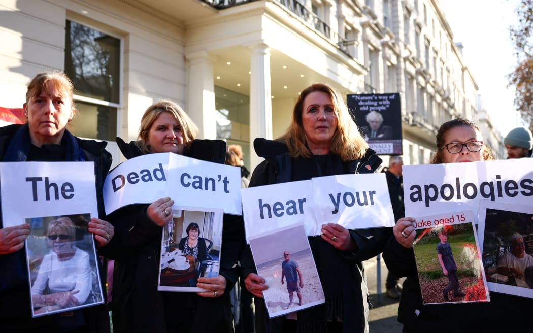 Protesters holds a placard reading "The dead can't hear your apologies" duing a gathering outside the UK Covid-19 Inquiry building in west London, on December 6, 2023 as Britain's former Prime Minister Boris Johnson is inside giving evidence regarding his management of the pandemic. Former UK prime minister Boris Johnson apologised for "the pain and the loss and the suffering" caused by the Covid-19 pandemic, as he began giving evidence on December 6, 2023 at a public inquiry into his government's handling of the health crisis. Nearly 130,000 people died with Covid in the UK by mid-July 2021, one of the worst official per capita tolls among Western nations. Johnson appears ready to insist the decisions he took ultimately saved hundreds of thousands of lives, the Times newspaper reported, citing a written statement that has not yet been published. (Photo by HENRY NICHOLLS / AFP)