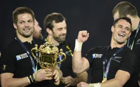New Zealand's flanker and captain Richie McCaw (L) holds the Webb Ellis Cup next to New Zealand's fly half Dan Carter as they celebrate with teammates after winning the final match of the 2015 Rugby World Cup