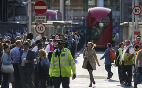 Early morning commuters form queues to board buses at Victoria station during a tube strike in London.