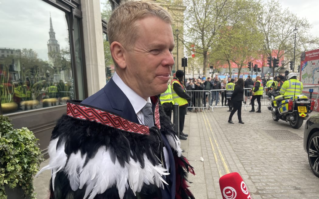 Prime Minister Chris Hipkins wearing a suit and Kakāhu as he departs for the Coronation.