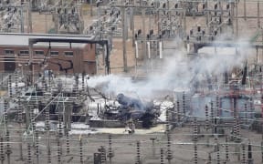 An aerial photograph taken on March 21, 2025 shows smoke billowing from a substation supplying power to Heathrow Airport amid efforts to douse the remainder of the flames after a fire broke out in Hayes, west London. Britain's Heathrow airport, Europe's busiest, was shut down early on March 21 for 24 hours after a major fire at an electricity substation cut power to the sprawling facility west of London, officials said. (Photo by AFP)