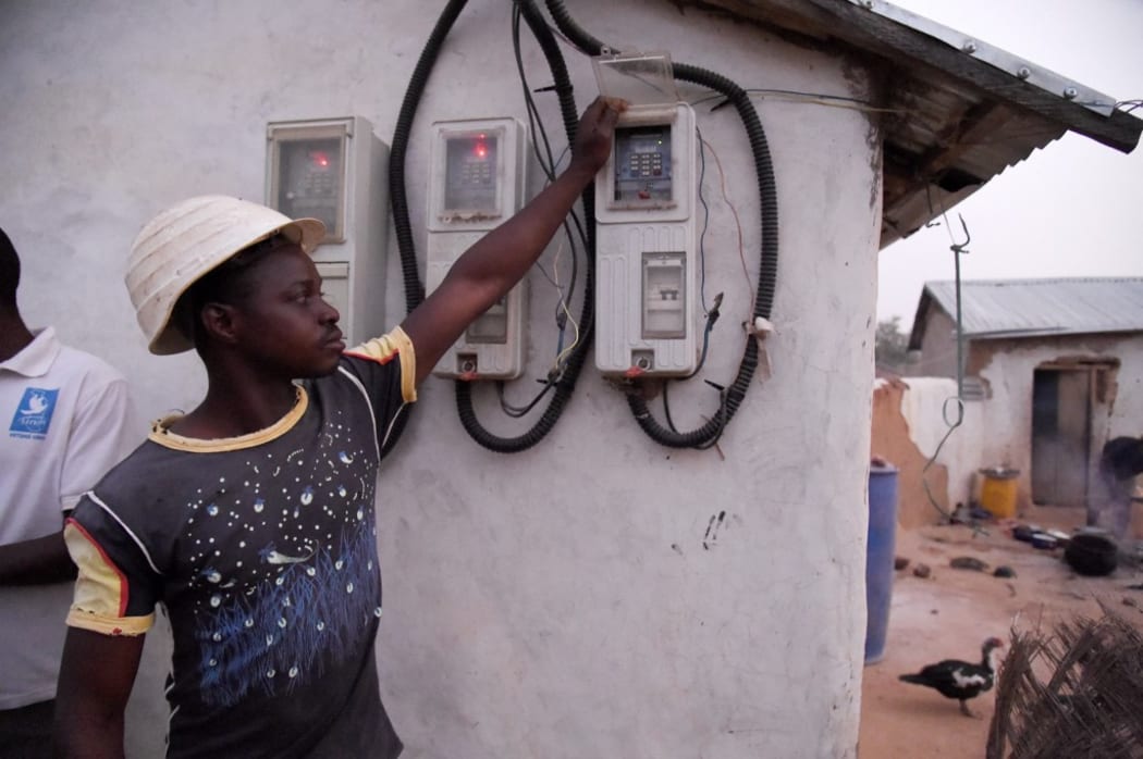 Site engineer Elassani Damoni touches prepaid meters powered by solar power installed in the Takpapieni village in Oti province, northern Togo,