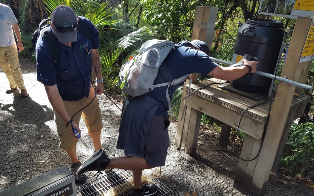 Visitors to the Waitākere Ranges use one of the hygiene stations to prevent the spread of Kauri dieback.