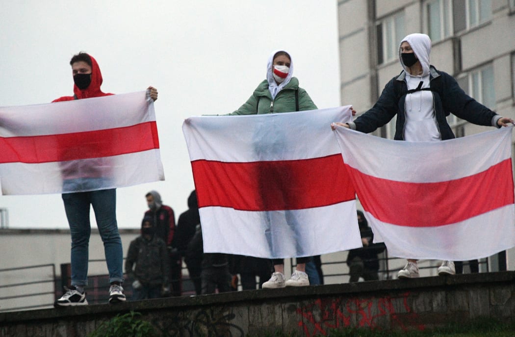 Protesters hold historical white-red-white flags of Belarus during a rally, in Minsk, Belarus.