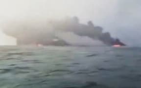 A screeshot of video showing smoke billowing as a cargo ship smashed into a US-flagged oil tanker carrying jet fuel off the northeast coast of England.