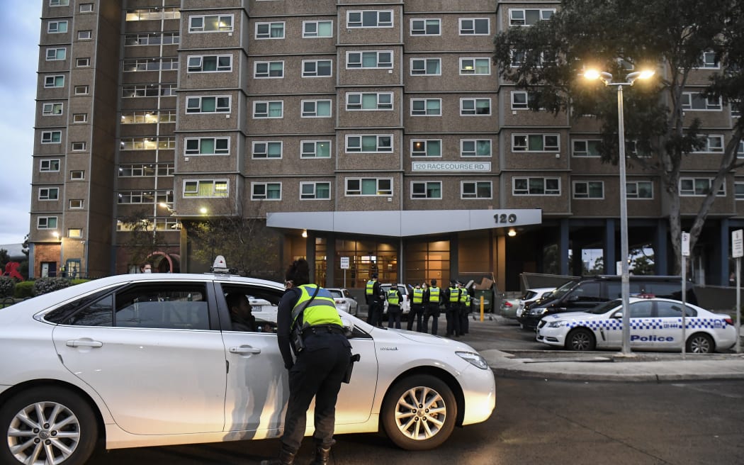 Police gather outside one of nine public housing estates which have been locked down in Melbourne.