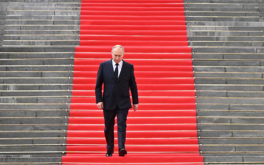 Russian President Vladimir Putin walks down the steps to address troops from the defence ministry, National Guard, FSB security service and interior ministry gathered on the Sobornaya (Cathedral) Square from the porch of the the Palace of the Facets on the grounds of the Kremlin in central Moscow on June 27, 2023. (Photo by Sergei GUNEYEV / SPUTNIK / AFP)