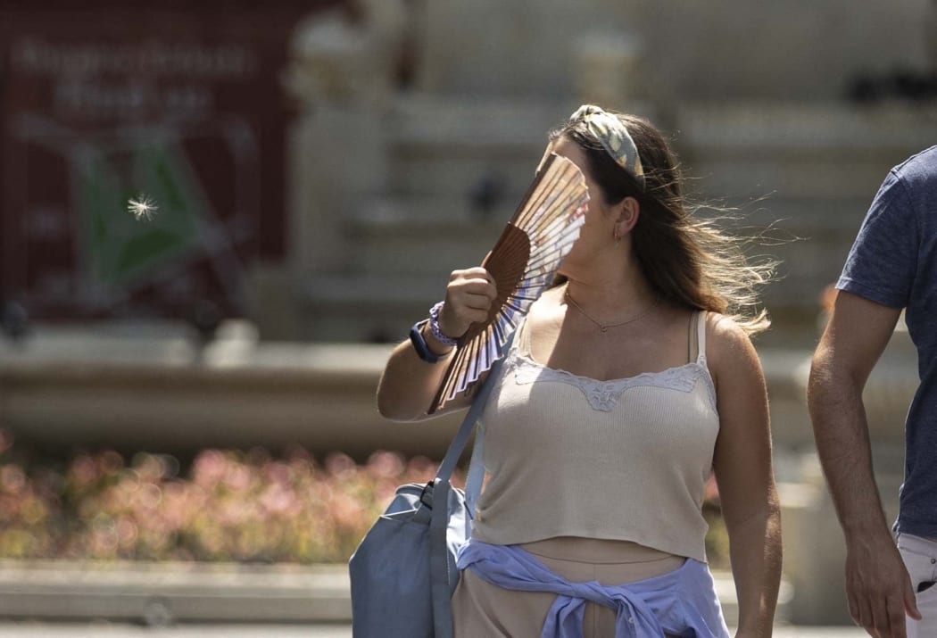 LONDON, UNITED KINGDOM - JULY 18: A woman, using a fan, is seen as heatwave hits London, United Kingdom on July 18, 2022. The UK Meteorological Service (Met Office) issued an extreme temperature warning that temperatures could reach 40 degrees Celsius, posing a serious risk on health. The "red" alert for extreme temperatures that affect adversely travel, health services and education will last until July 19th. Rasid Necati Aslim / Anadolu Agency (Photo by Rasid Necati Aslim / ANADOLU AGENCY / Anadolu Agency via AFP)