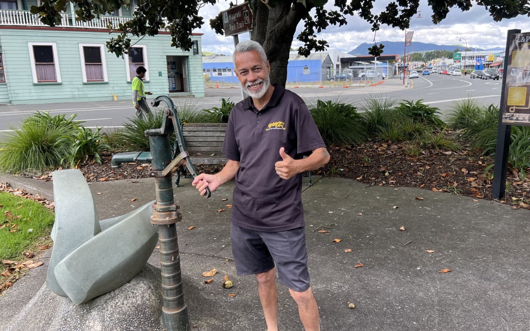 Rino Wilkinson at one of the old mineral cast iron water pumps in Paeroa.