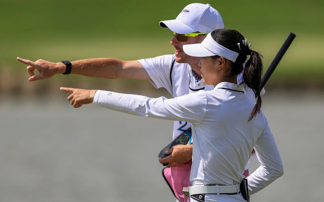 New Zealand's Lydia Ko speaks with her caddie during round 3 of the women’s golf individual stroke play of the Paris 2024 Olympic Games at Le Golf National in Guyancourt, south-west of Paris on August 9, 2024. (Photo by Emmanuel DUNAND / AFP)