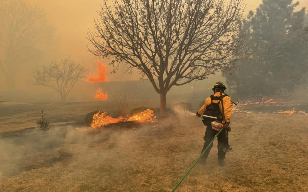 This handout picture courtesy of the Flower Mound Fire Department taken on 28 February, 2024, shows a firefighter battling the Smokehouse Creek Fire, near Amarillo, in the Texas Panhandle.