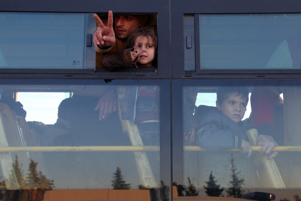 Syrians, who were evacuated from rebel-held neighbourhoods in the embattled city of Aleppo, arrive in the opposition-controlled Khan al-Aassal region, west of the city, on December 15, 2016, the first stop on their trip.