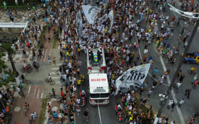 In this aerial picture fans of the late Brazilian football star Pele gather on the street as a firetruck transports Pele's coffin to the Santos' Memorial Cemetery in Santos, Sao Paulo state, Brazil on 3 January, 2023.