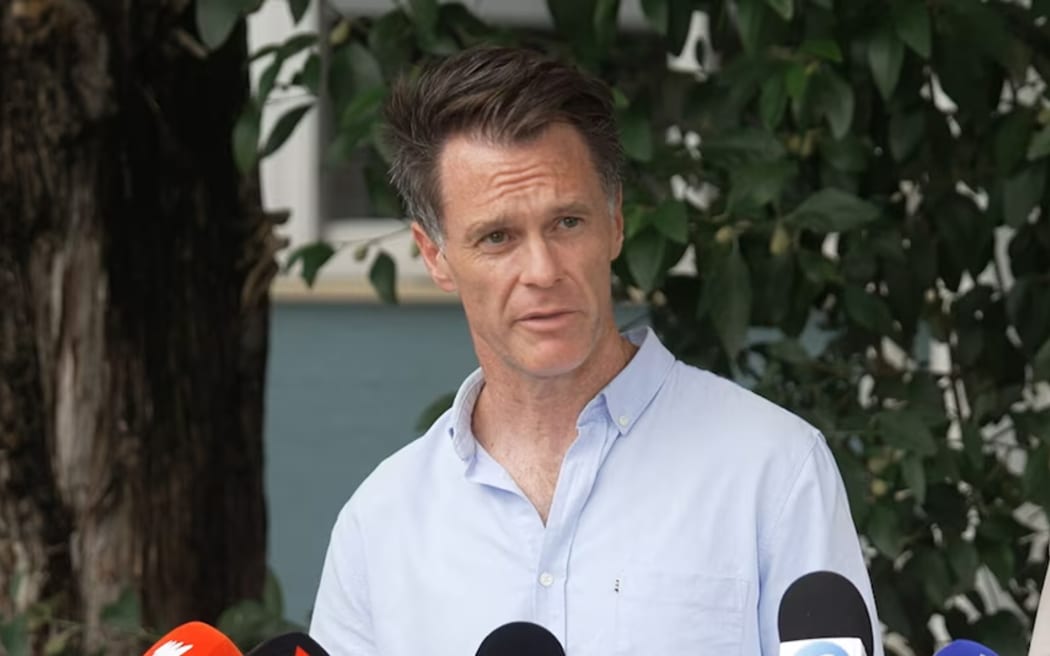 New South Wales premier Chris Minns stands outdoors speaking to the media.