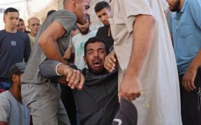 A Palestinian mourner breaks in tears during the funeral procession of people reportedly killed while waiting for aid delivery, in Gaza City, on 3 July, 2025.