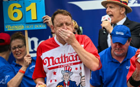 Defending champion Joey Chestnut competes in the 2023 Nathan's Famous Fourth of July International Hot Dog Eating Contest on July 4, 2023 at Coney Island in the Brooklyn borough of New York City. The men's contest was postponed due to thunderstorms but later happened without spectators allowed into the "arena." The annual contest, which began in 1972, draws thousands of spectators to Nathan’s Famous located on Surf Avenue.