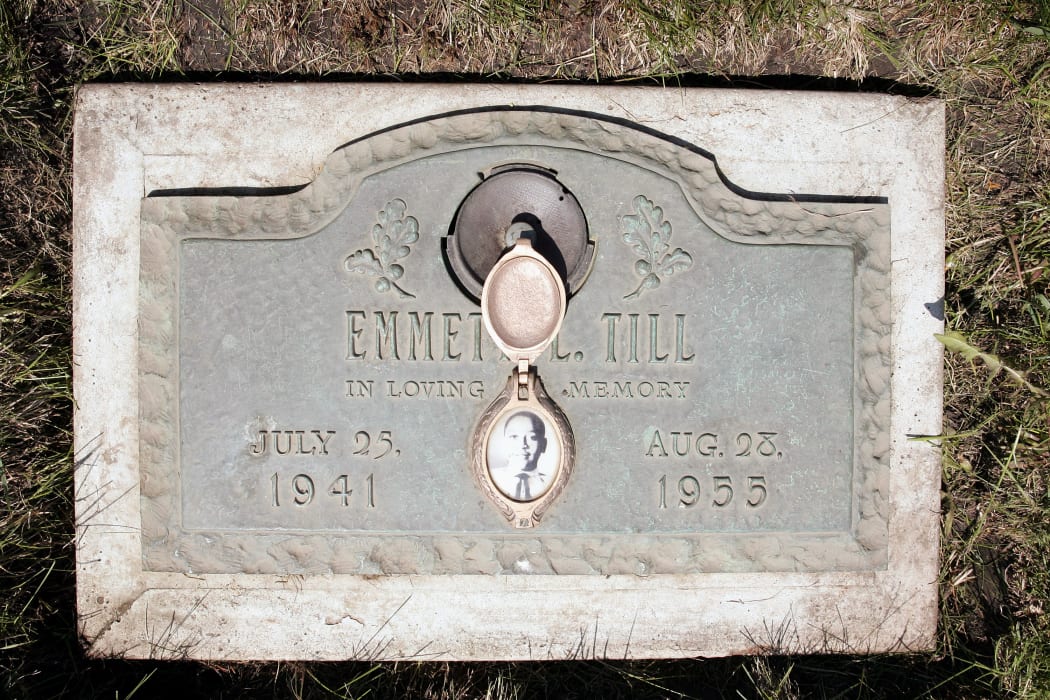 A photo of Emmett Till is included on the plaque that marks his grave site at Burr Oak Cemetery in Aslip, Illinois.