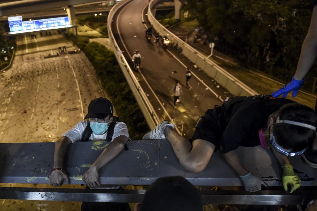 Protesters lower themselves down with a rope down from a bridge to a highway, to escape from Hong Kong Polytechnic University campus.