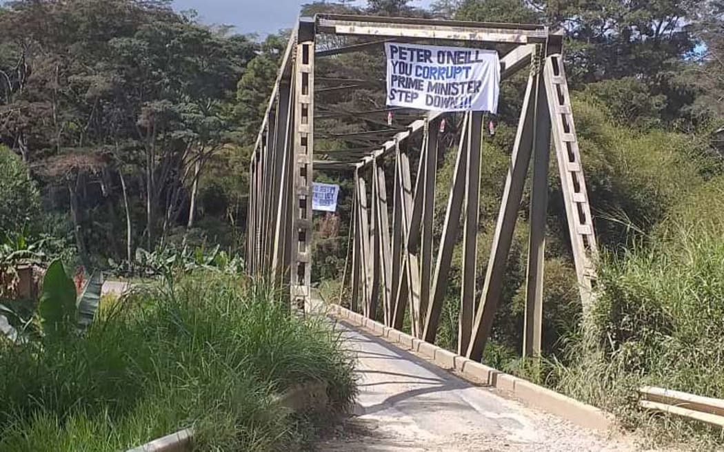 A banner on a bridge in Papua New Guinea's Eastern Highlands hangs in opposition to Peter O'Neill.