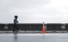 A person braving the fierce winds in Wellington on 2 October, 2023.